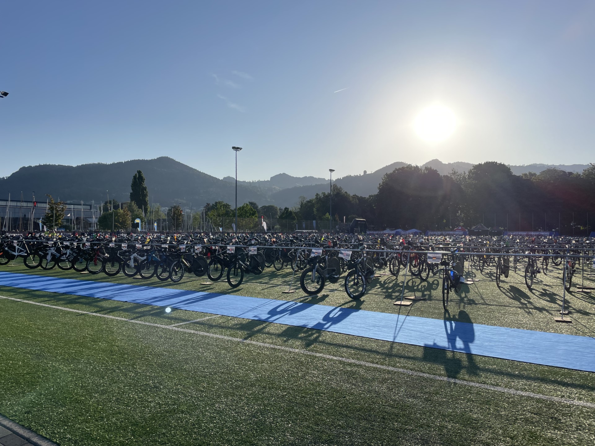Ironman Switzerland showing bikes racked in transition with a hilly backdrop.